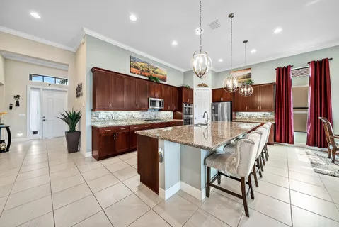 a large kitchen with a large counter top space appliances and cabinets