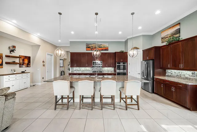 a kitchen with stainless steel appliances kitchen island granite countertop a refrigerator and cabinets
