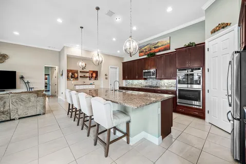 a kitchen with stainless steel appliances kitchen island granite countertop a refrigerator and a stove top oven