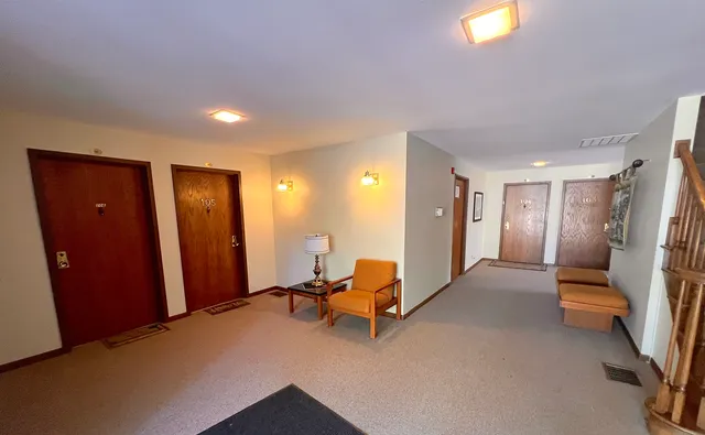 a living room with furniture and a hallway