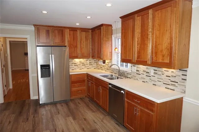 a kitchen with a sink refrigerator and cabinets