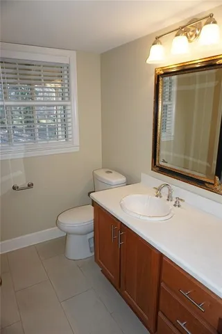 a bathroom with a toilet sink and mirror
