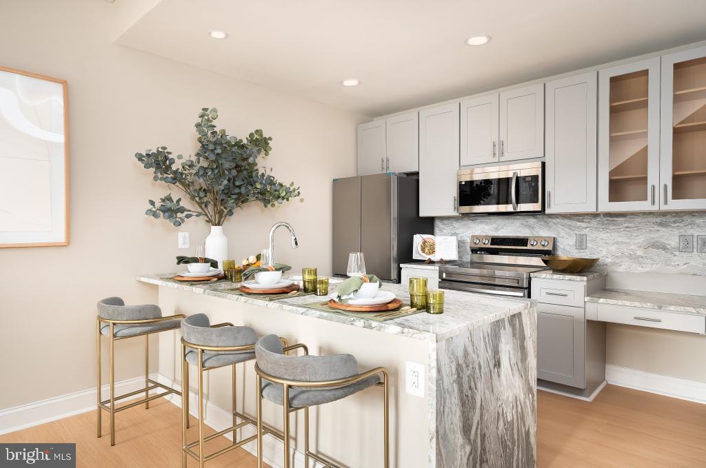 2301-61 John F Kennedy Boulevard, Unit 1902 Philadelphia, PA 19103 - Photo 4 of 39 a kitchen with a sink a stove and chairs