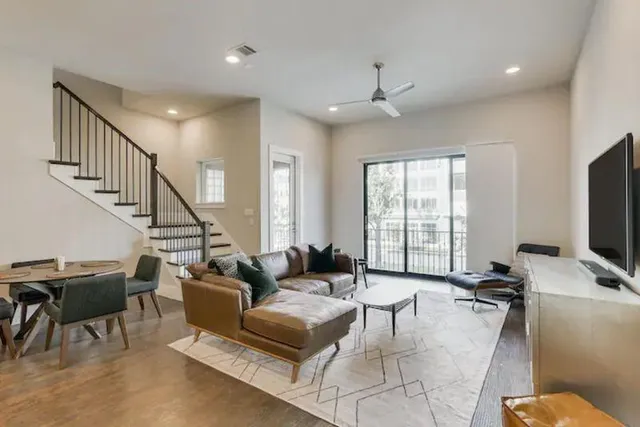 a living room with furniture a ceiling fan and a window
