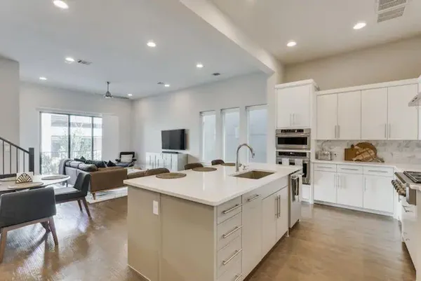 a view of a kitchen with kitchen island a sink appliances and a counter top space
