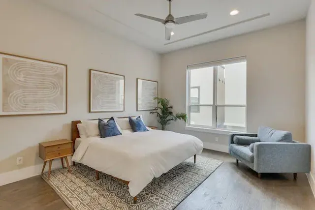 a bedroom with a bed a couch and windows