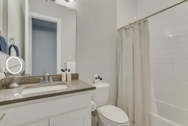 a bathroom with a granite countertop sink toilet and shower