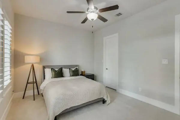 a bedroom with a bed and a ceiling fan