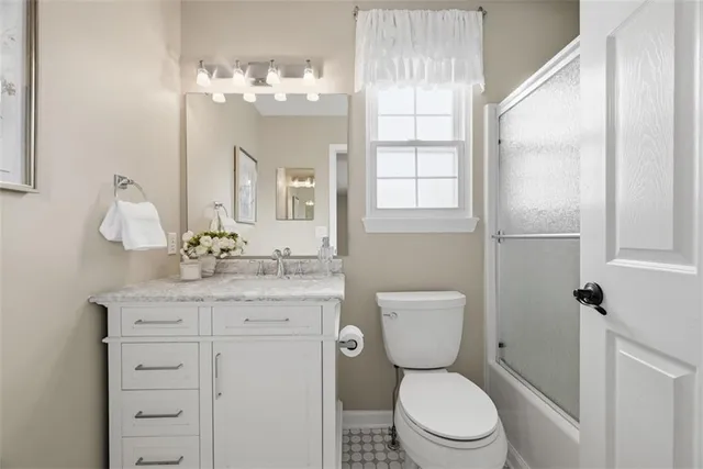 a bathroom with a granite countertop toilet sink and mirror