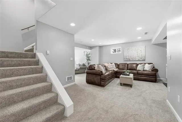 a living room with furniture and stairs