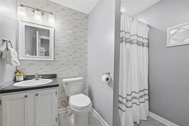 a bathroom with a toilet a sink and mirror