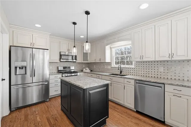 a kitchen with a sink stainless steel appliances a sink and a refrigerator