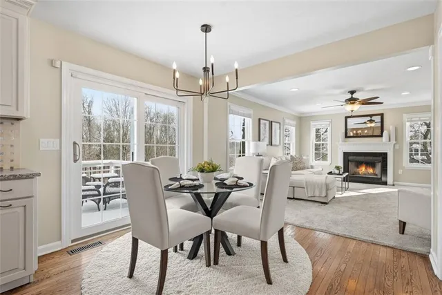 a dining room with furniture a chandelier and wooden floor