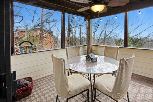 a view of a dining room with furniture one side kitchen view and wooden floor