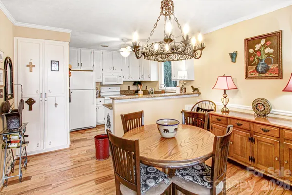 a view of a dining room with furniture a chandelier and wooden floor