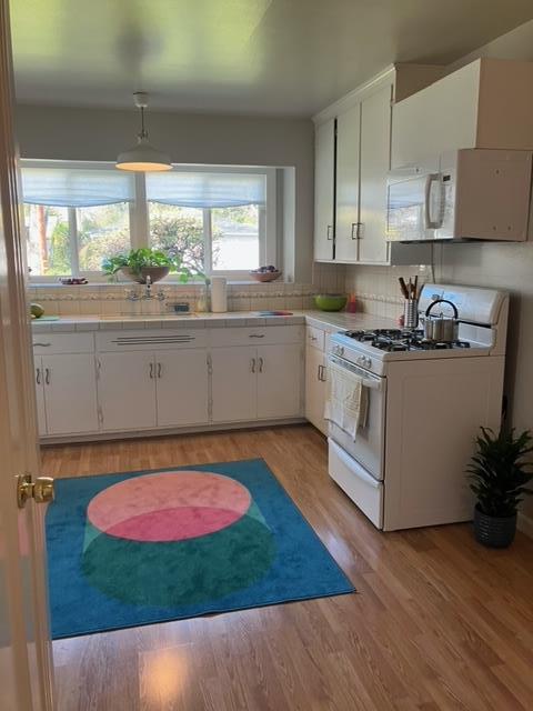 310 McKendry Drive Menlo Park, CA 94025 - Photo 4 of 14 a kitchen with stainless steel appliances granite countertop a stove a sink and white cabinets with wooden floor