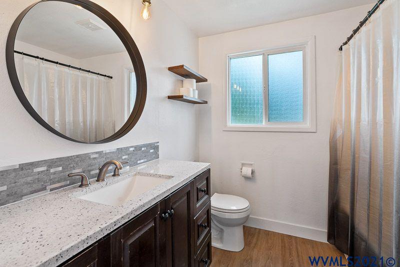 1121 Fabry Road Southeast Salem, OR 97306 - Photo 25 of 31 a bathroom with a granite countertop sink and a mirror