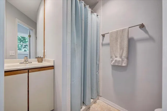 an aerial view of a house with outdoor space and trees all around