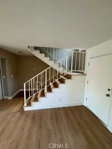 a view of entryway and hall with wooden floor