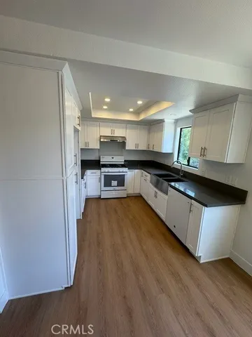 a kitchen with stainless steel appliances granite countertop a stove a sink and a refrigerator