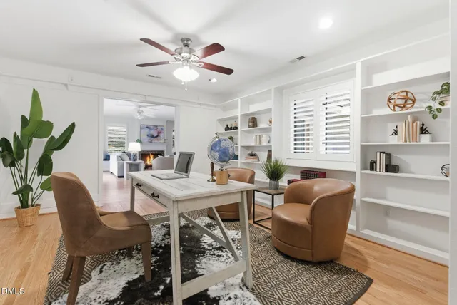an empty room with windows and ceiling fan