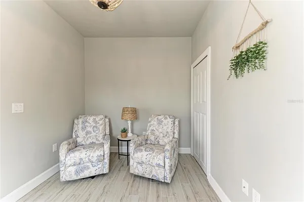a spacious bedroom with furniture and wooden floor