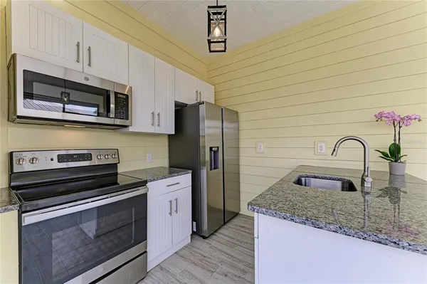 a kitchen with stainless steel appliances granite countertop a stove a sink and a refrigerator