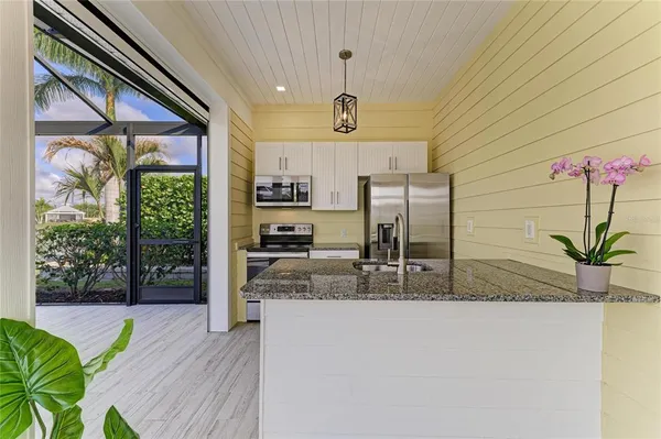 a large kitchen with stainless steel appliances a large counter top a stove and a wooden floors