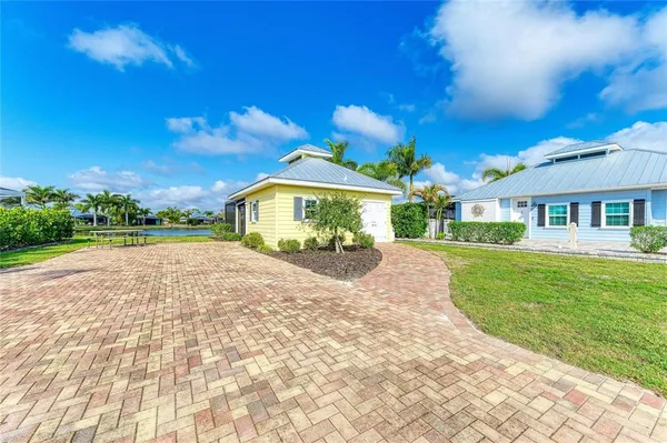 a front view of a house with a yard and potted plants