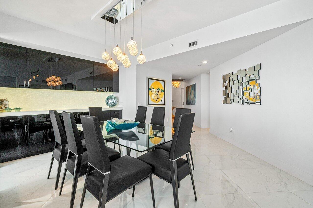 2640 Lake Shore Drive, Unit 2307 Riviera Beach, FL 33404 - Photo 12 of 64 a view of a dining room with furniture and chandelier