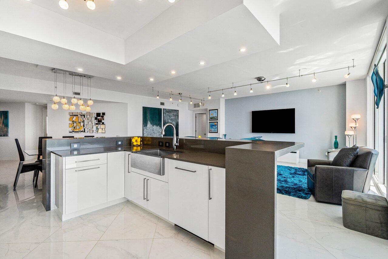 2640 Lake Shore Drive, Unit 2307 Riviera Beach, FL 33404 - Photo 17 of 64 a living room with furniture and a flat screen tv