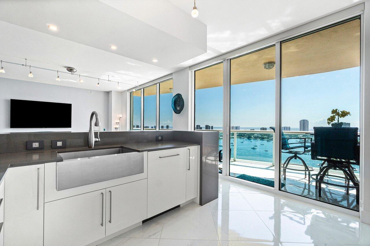 2640 Lake Shore Drive, Unit 2307 Riviera Beach, FL 33404 - Photo 20 of 64 a view of a kitchen with kitchen island a large window a sink and a large window