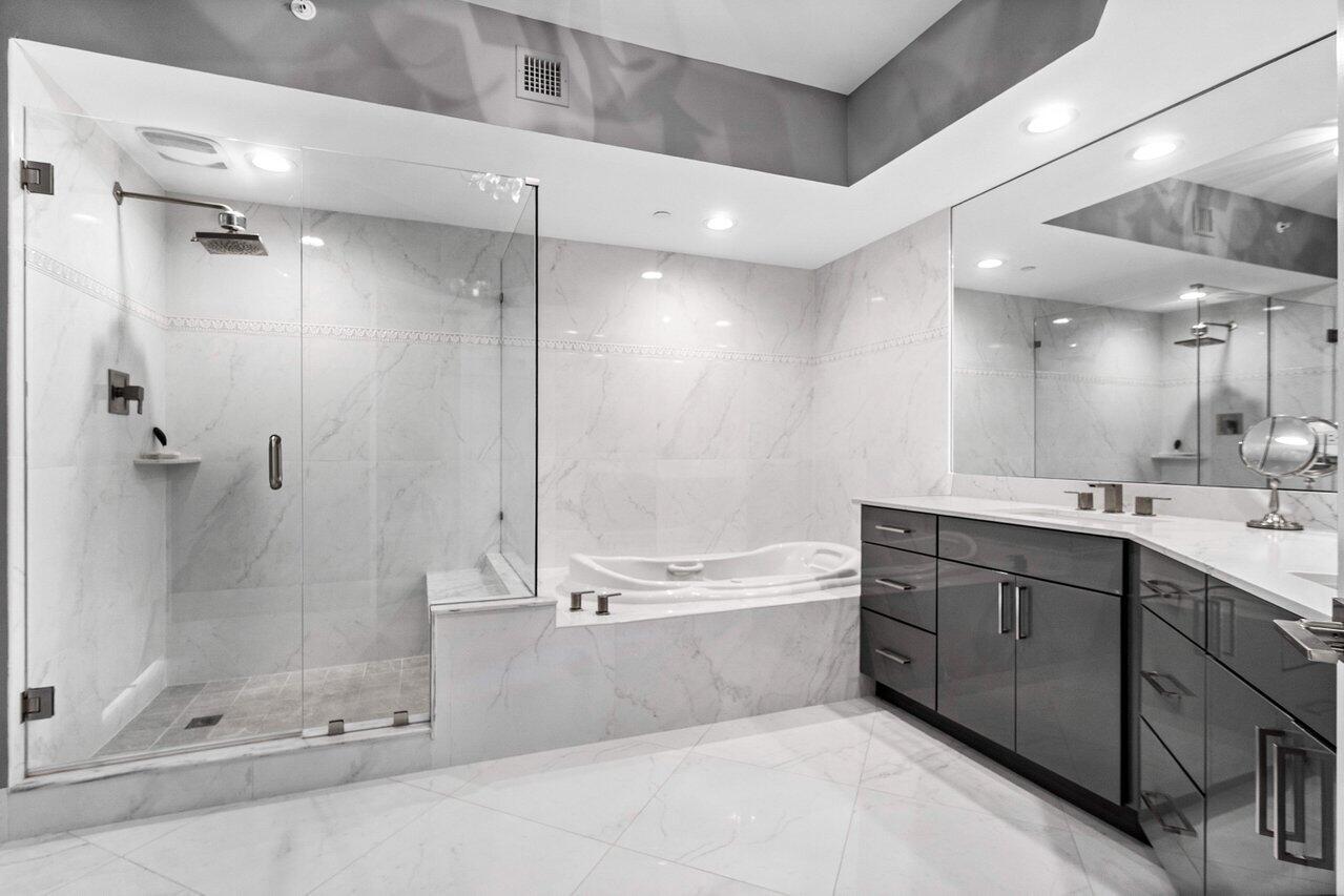 2640 Lake Shore Drive, Unit 2307 Riviera Beach, FL 33404 - Photo 26 of 64 a bathroom with a tub shower sink and mirror