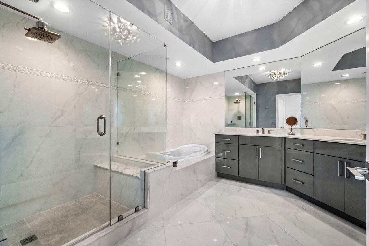 2640 Lake Shore Drive, Unit 2307 Riviera Beach, FL 33404 - Photo 27 of 64 a large bathroom with a glass door shower sink and mirror