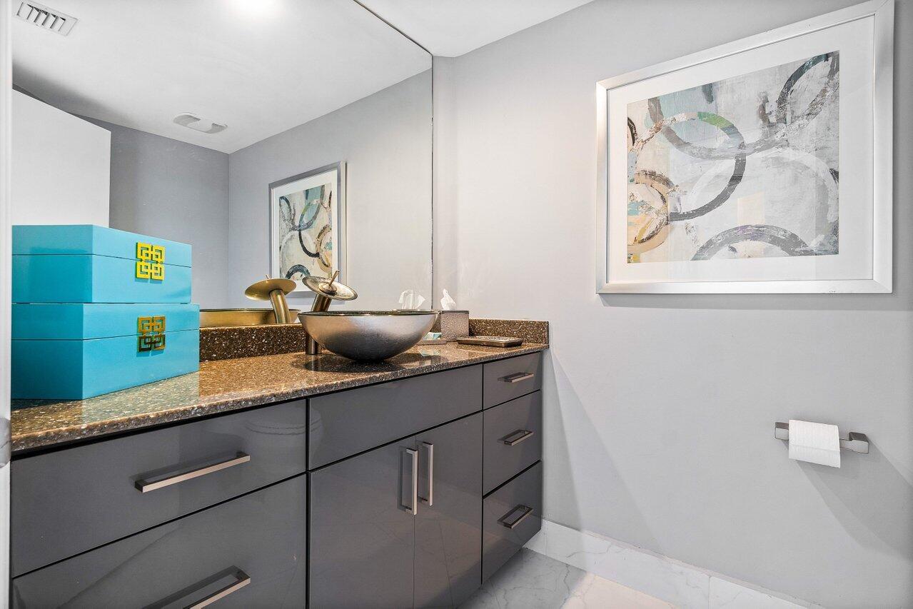 2640 Lake Shore Drive, Unit 2307 Riviera Beach, FL 33404 - Photo 33 of 64 a kitchen with a sink and a painting on the wall