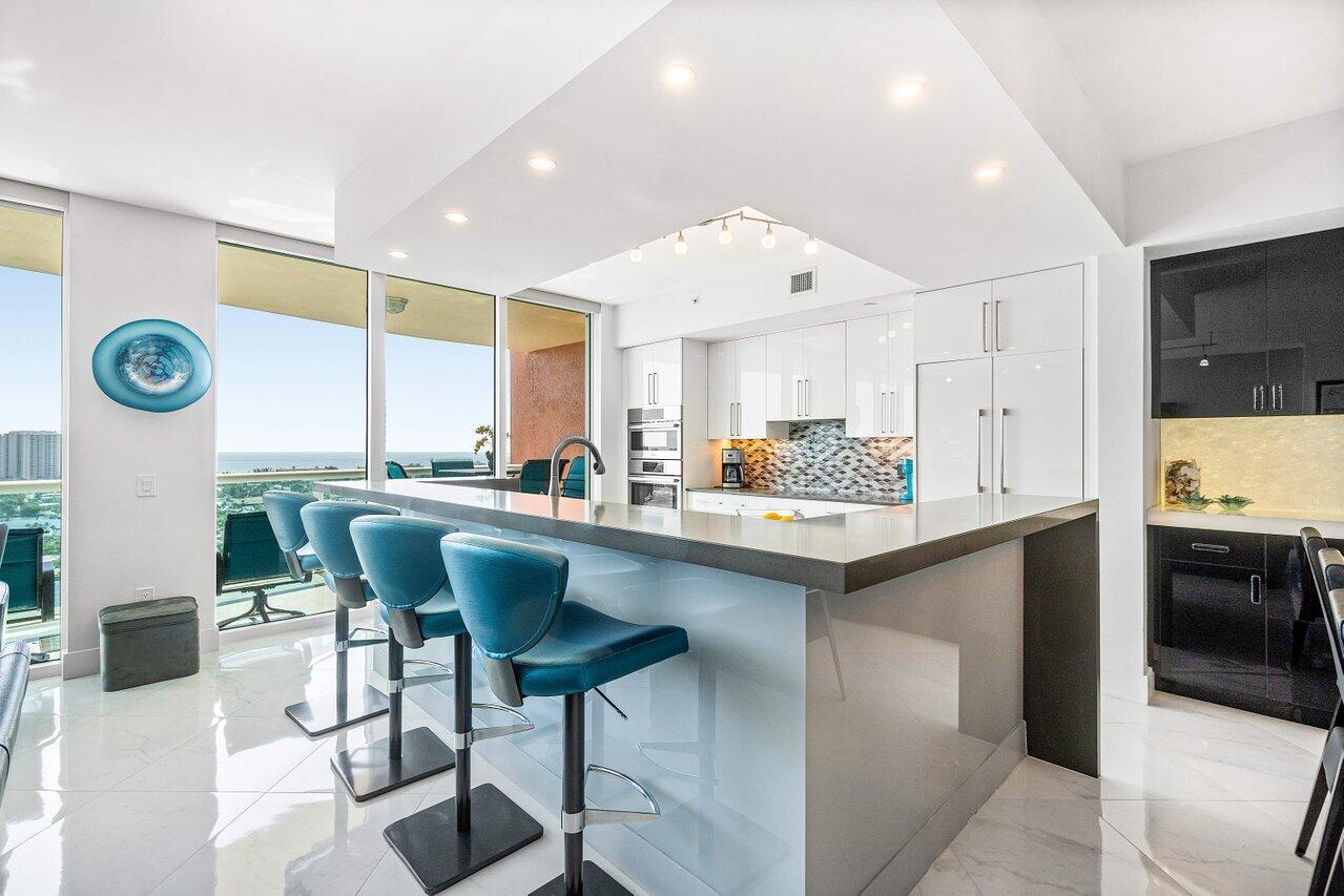 2640 Lake Shore Drive, Unit 2307 Riviera Beach, FL 33404 - Photo 8 of 64 a kitchen with stainless steel appliances granite countertop a sink and a refrigerator