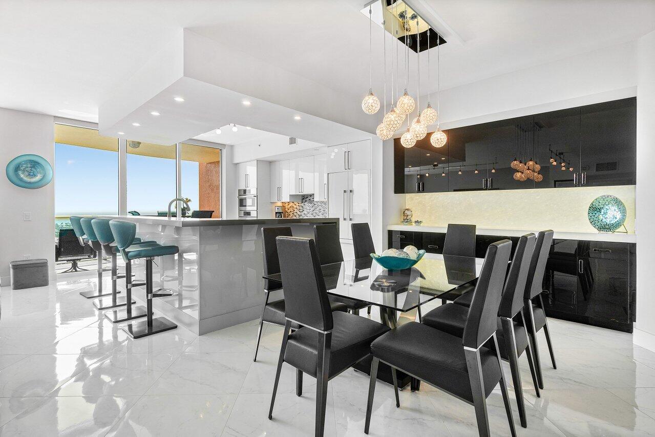 2640 Lake Shore Drive, Unit 2307 Riviera Beach, FL 33404 - Photo 9 of 64 a dining room with kitchen island furniture a chandelier and kitchen view