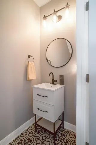 a bathroom with a sink mirror and vanity