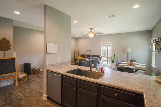 a kitchen with sink and view of living room