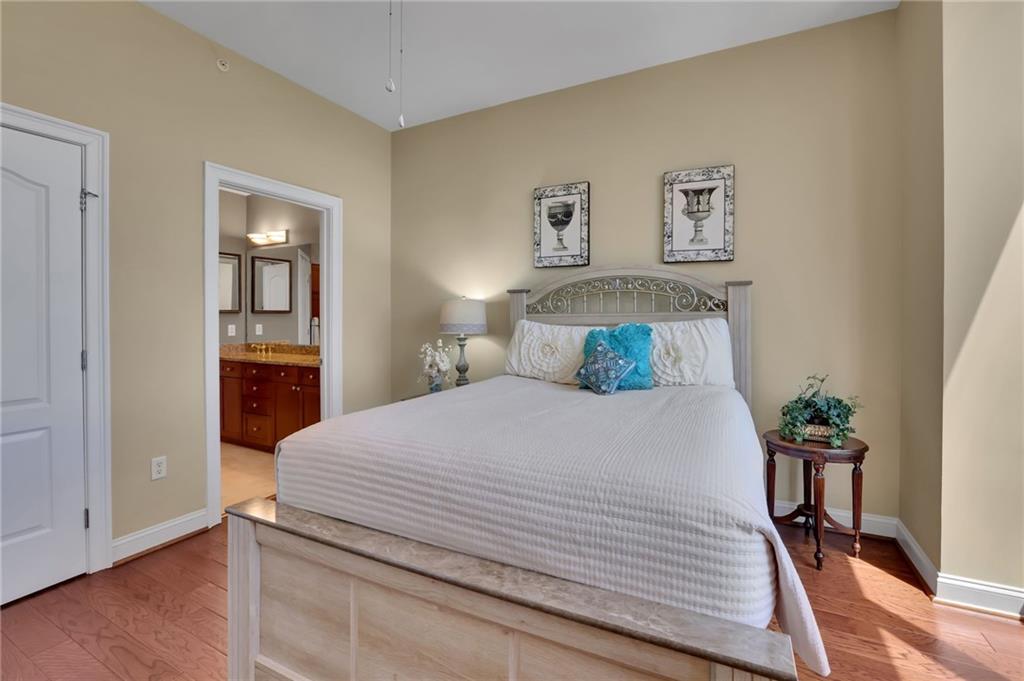 2828 Peachtree Road Northwest, Unit 1901 Atlanta, GA 30305 - Photo 17 of 35 a bedroom with a bed and a painting on the wall