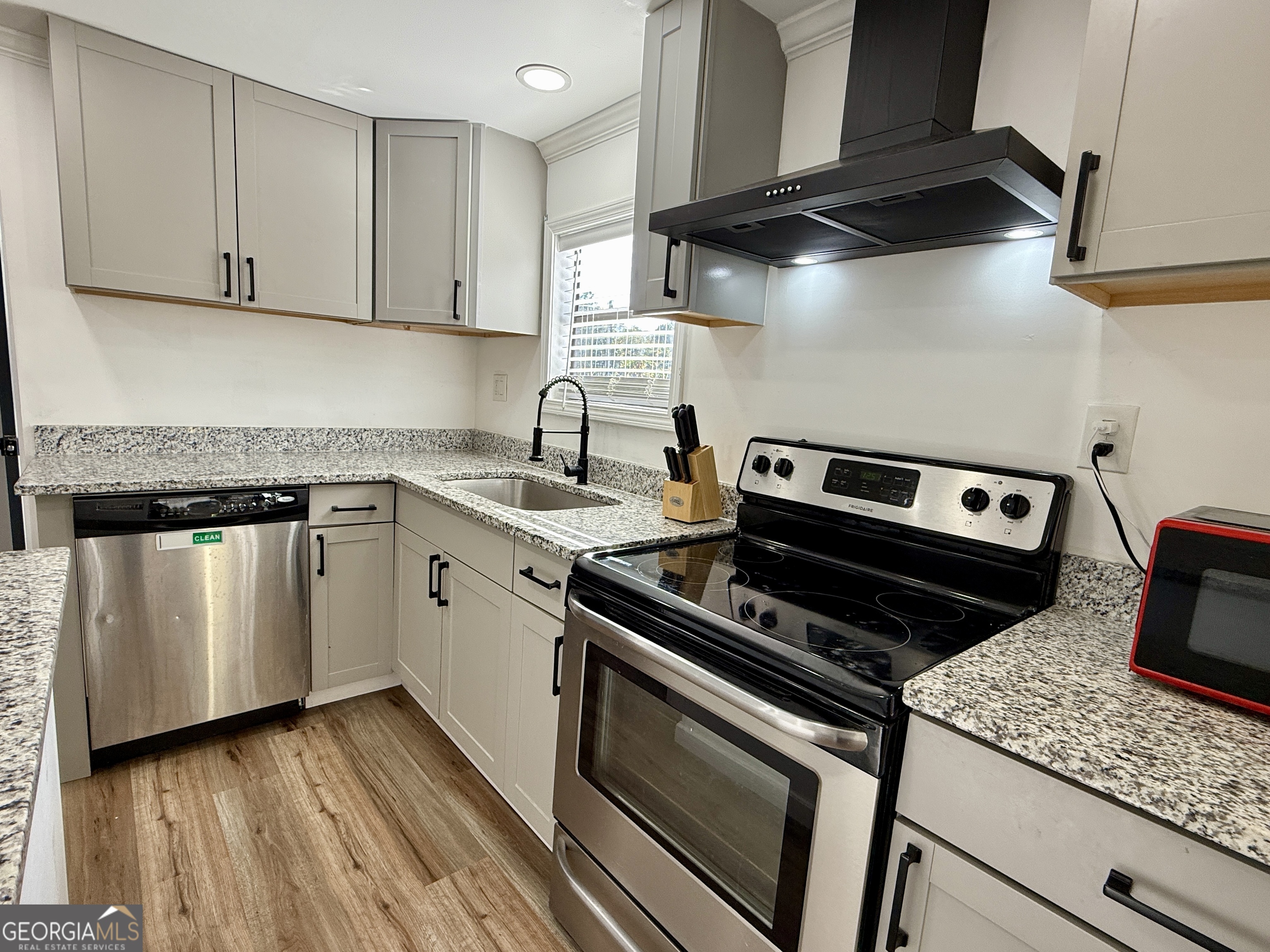 10199 Ga Highway Stapleton, GA 30823 - Photo 11 of 30 a kitchen with white cabinets stainless steel appliances and wooden floor