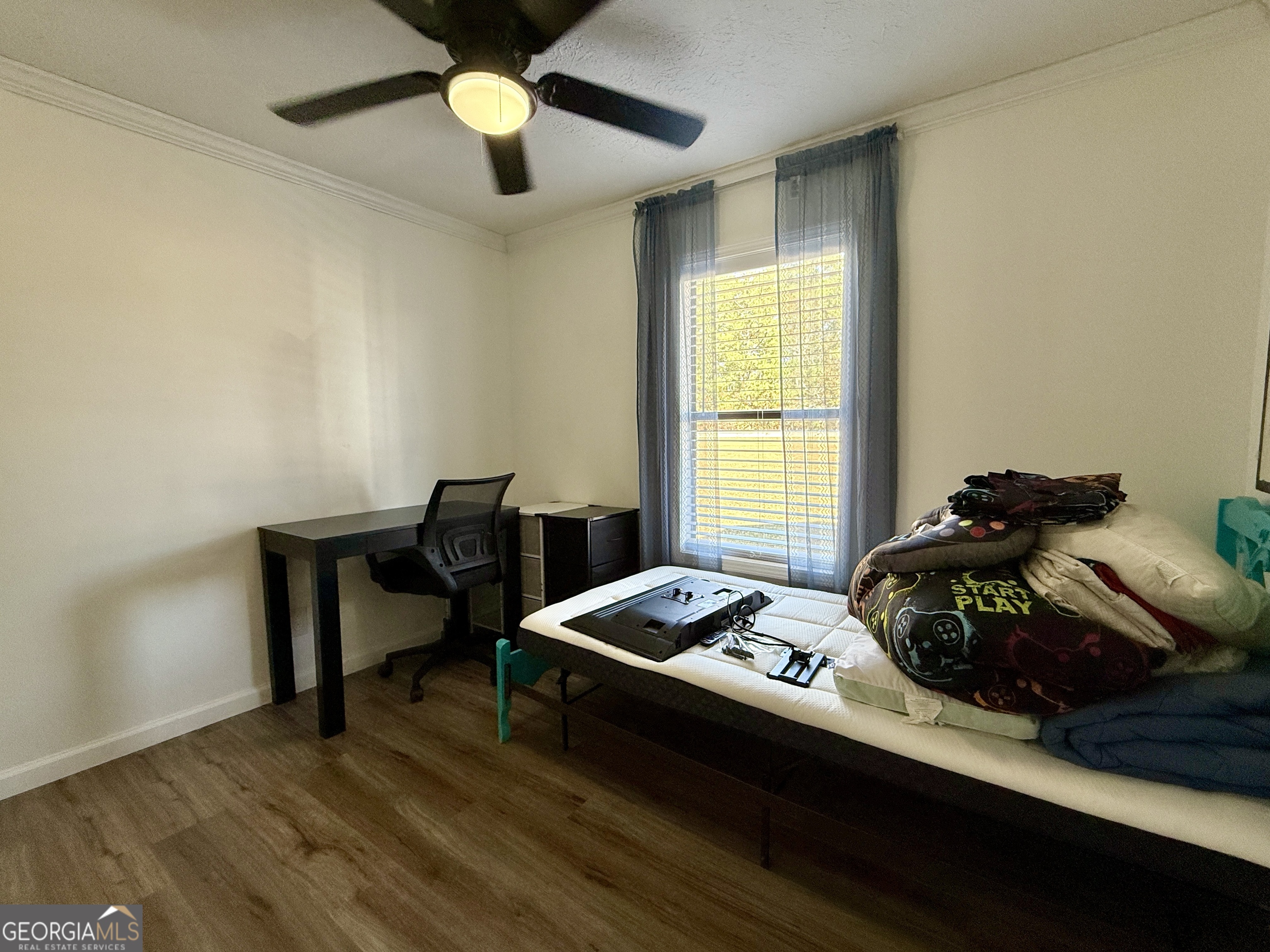 10199 Ga Highway Stapleton, GA 30823 - Photo 22 of 30 a bedroom with a bed and a chandelier