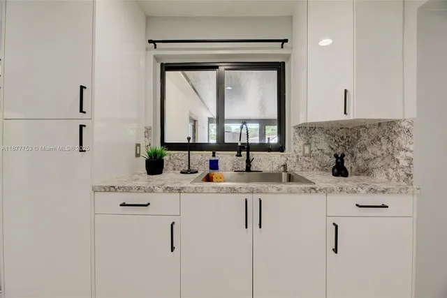 a bathroom with a granite countertop sink a vanity and a mirror