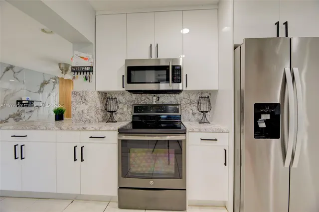 a kitchen with stainless steel appliances granite countertop a refrigerator sink and stove