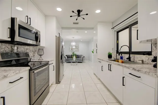a kitchen with stainless steel appliances a sink stove and cabinets