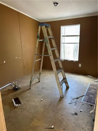 a living room with a couch a rug and a gym machine next to a window