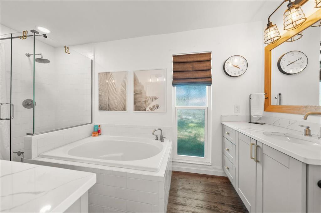 1049 McCarty Street Dunedin, FL 34698 - Photo 14 of 49 a bathroom with a tub sink and mirror
