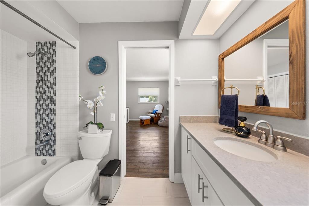 1049 McCarty Street Dunedin, FL 34698 - Photo 17 of 49 a bathroom with a granite countertop sink mirror vanity and toilet