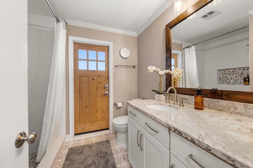 1049 McCarty Street Dunedin, FL 34698 - Photo 21 of 49 a bathroom with a granite countertop sink and a mirror