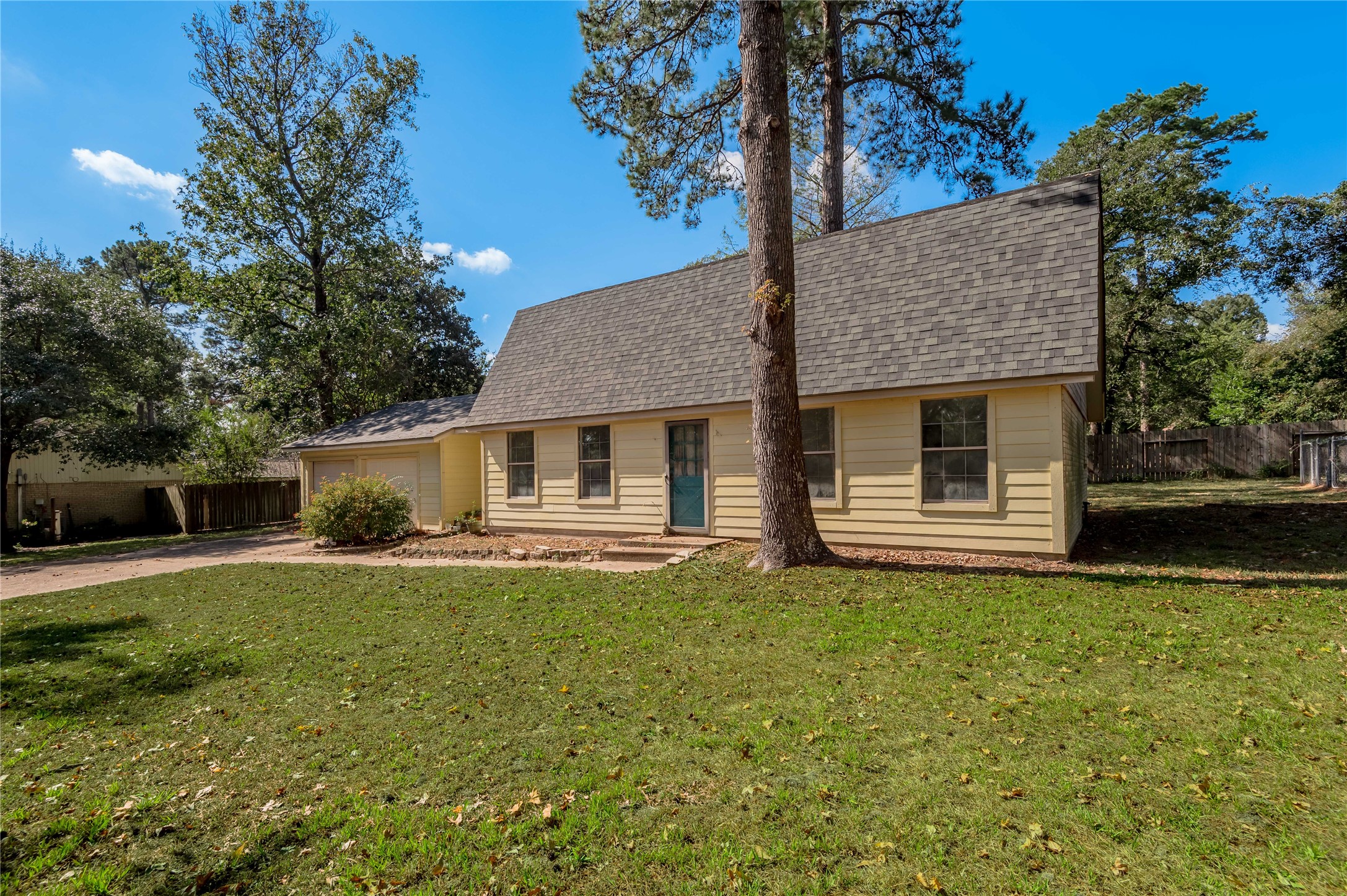 3644 Sage Street Huntsville, TX 77340 - Photo 2 of 20 a front view of a house with a garden and trees